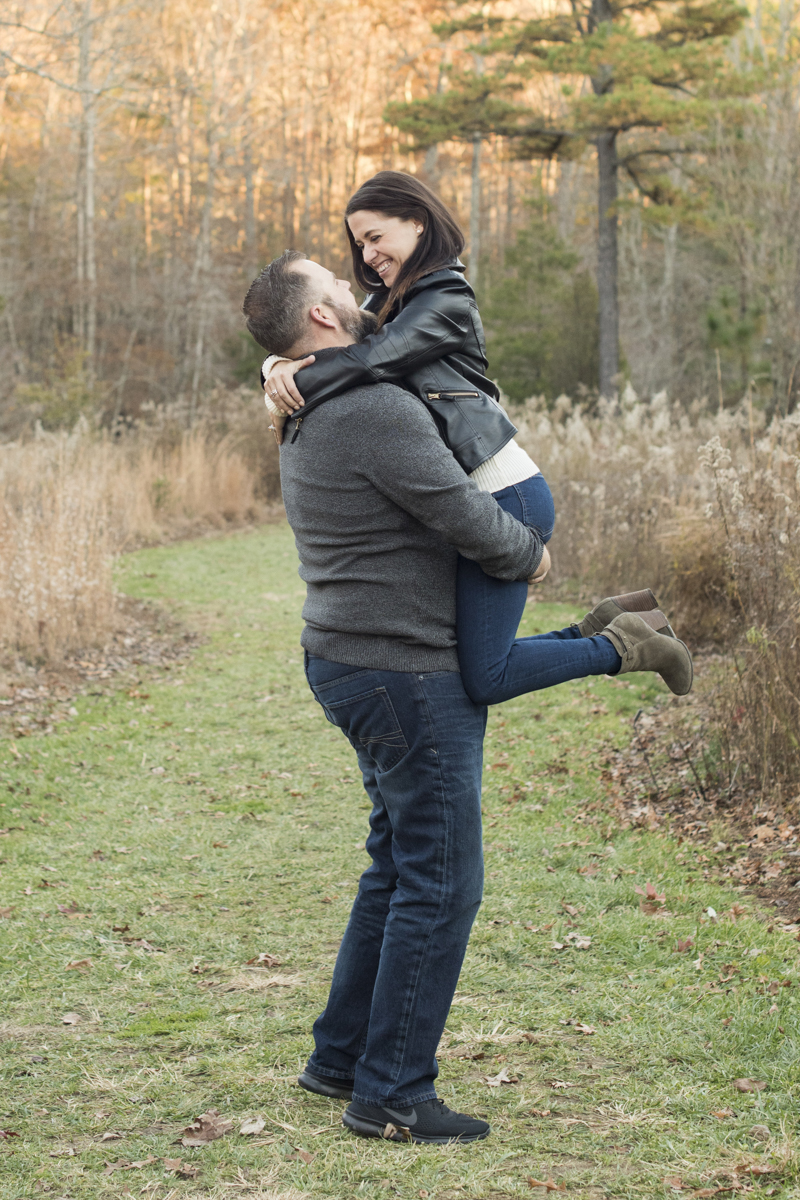 Man picking up woman and smiling during engagement photos in Asheville, NC