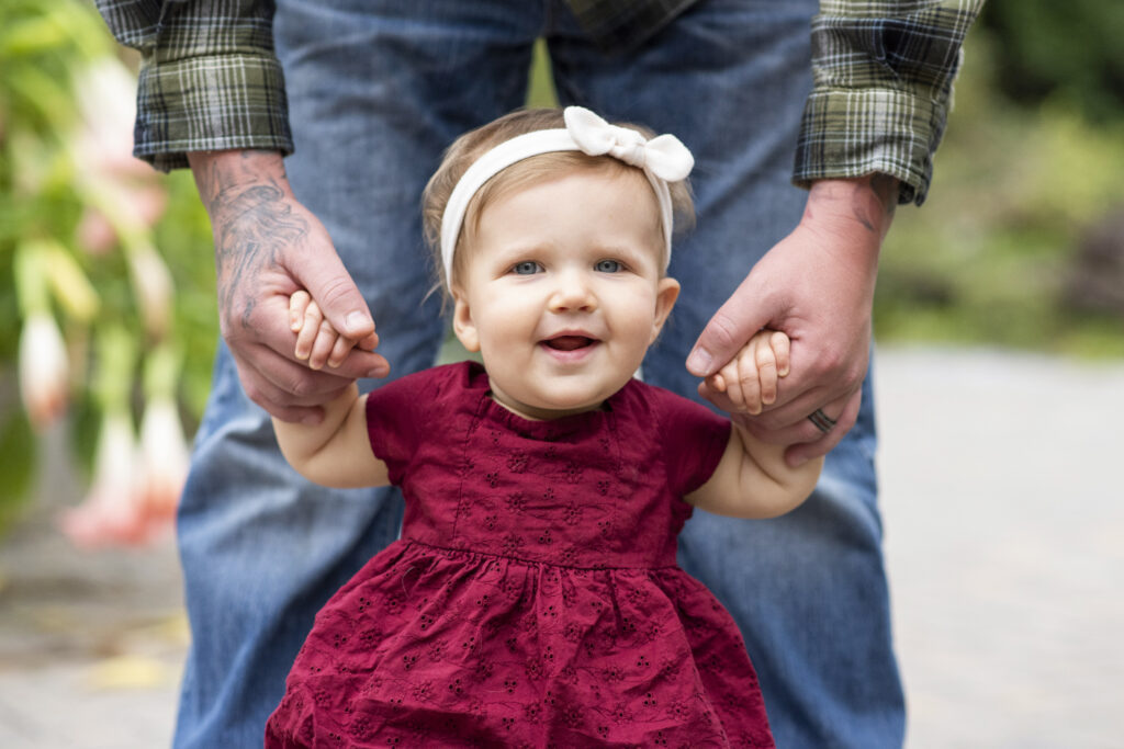little girl holding dads hands