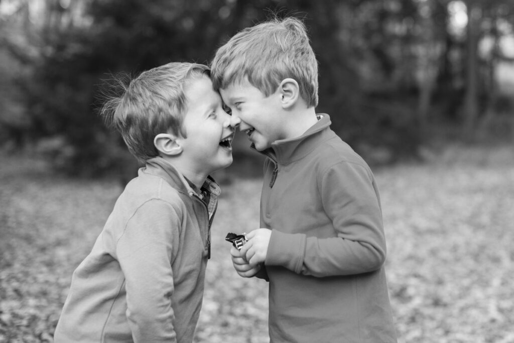 twin boys laughing during photo shoot in black and white