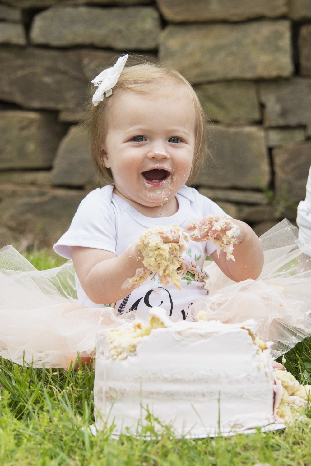 One year old birthday girl eating cake in tutu