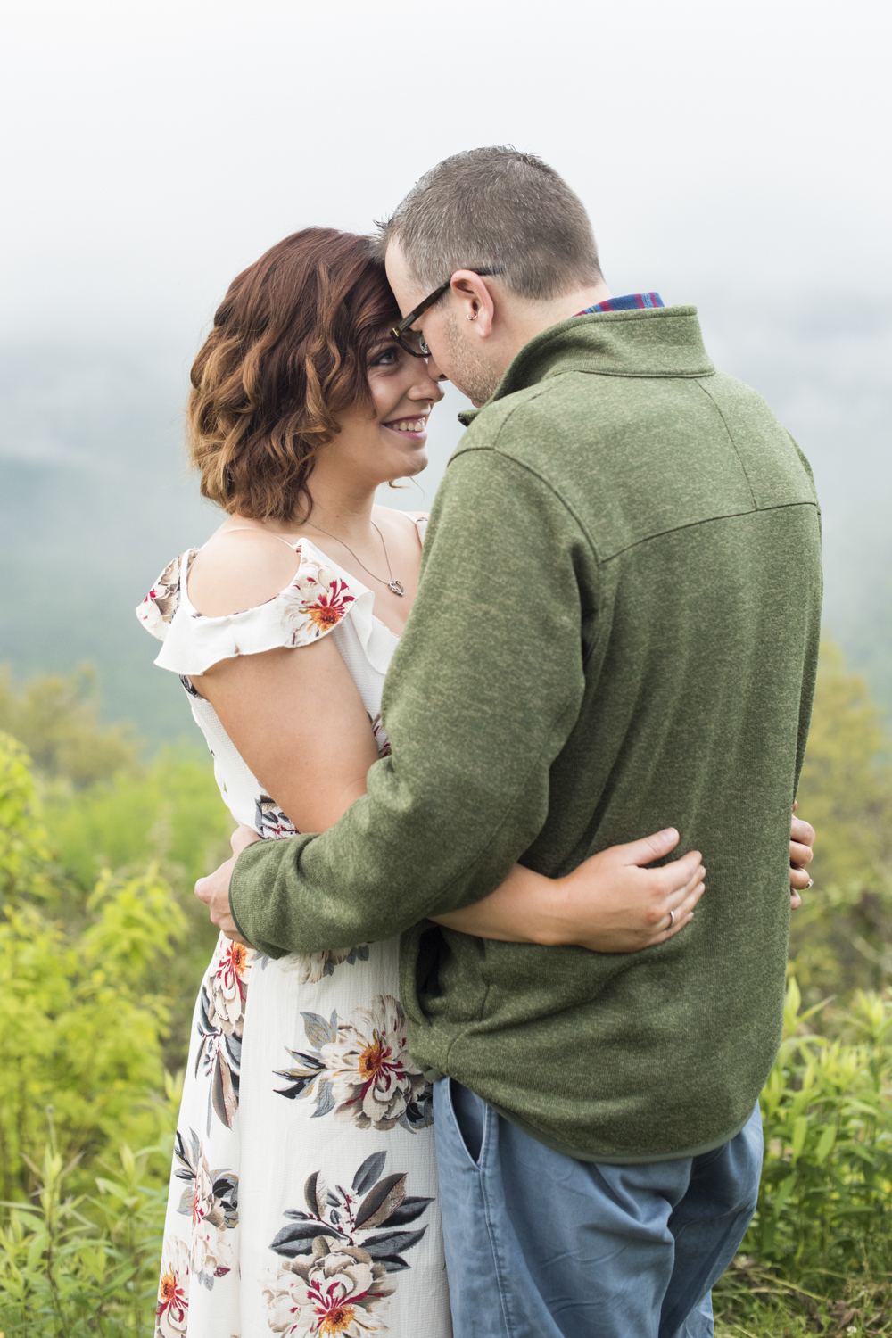 Couple snuggling on Blue Ridge Parkway at Engagement Photo Locations in Asheville