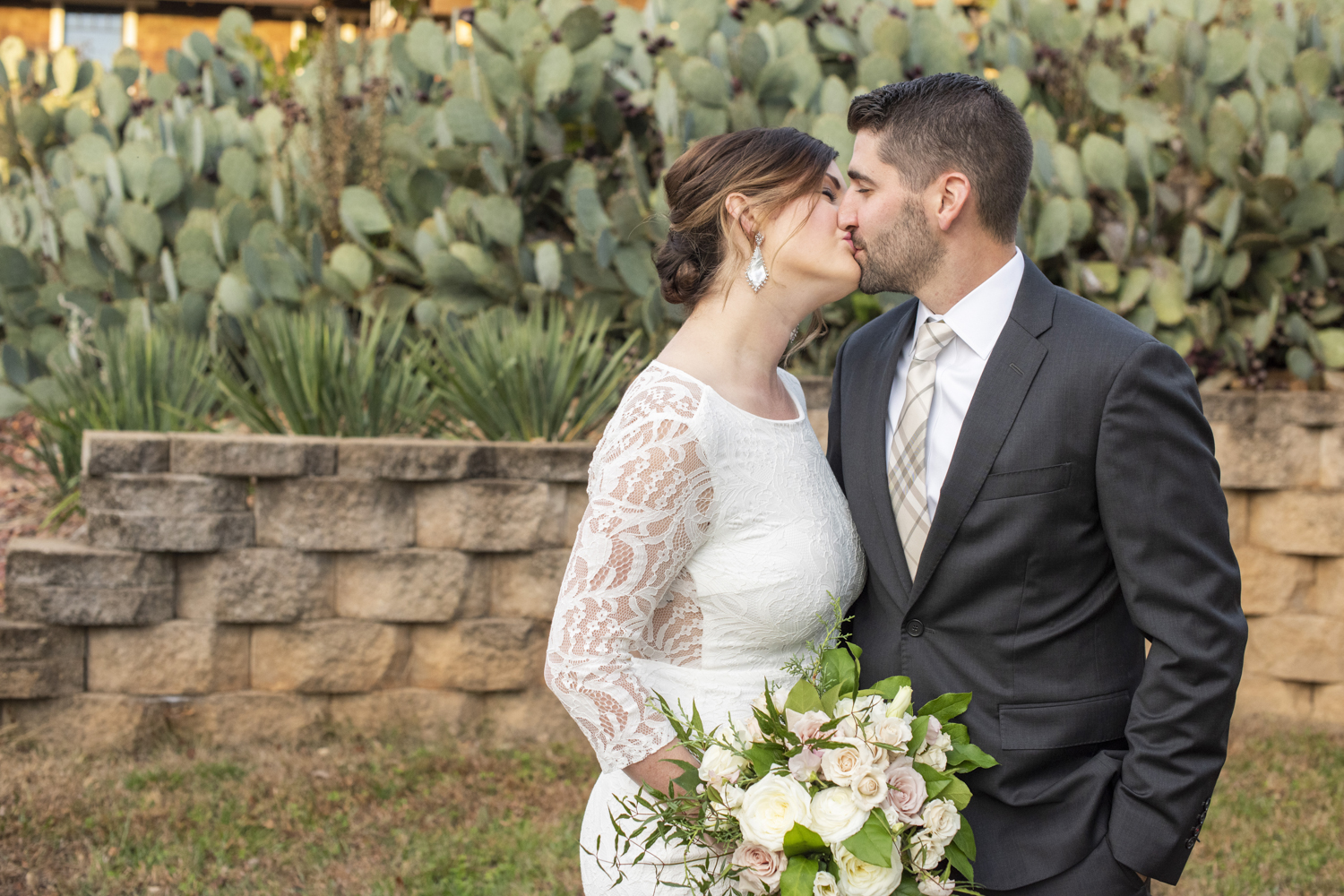 Couple kissing in front of cactus