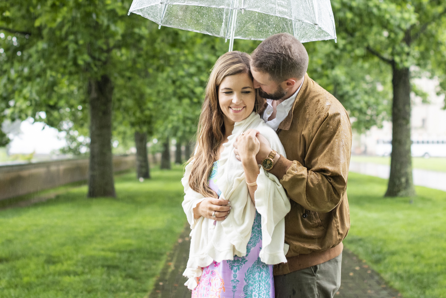 Couple snuggling under umbrella at Biltmore Estate