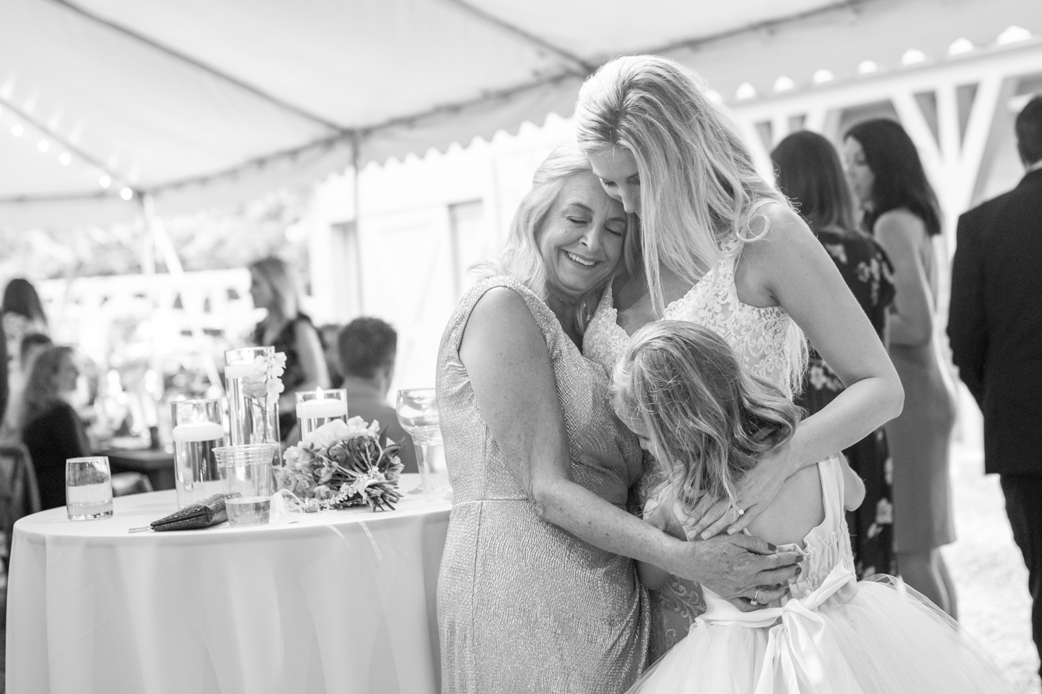 Bride, mother, and daughter hugging