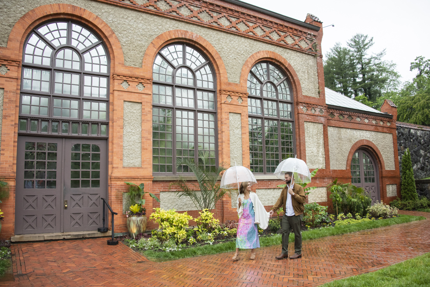 Couple walking in front of conservatory after proposal