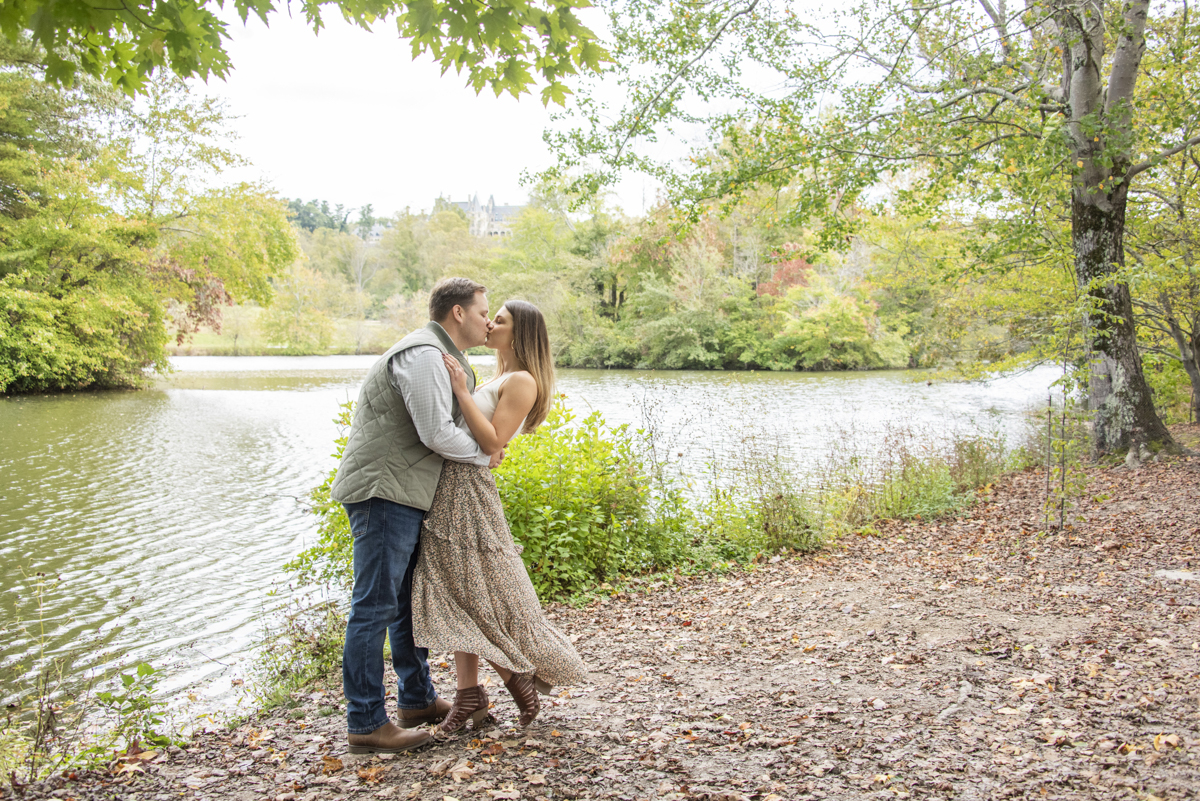 Biltmore Estate Engagement Photographer couple kissing at lagoon