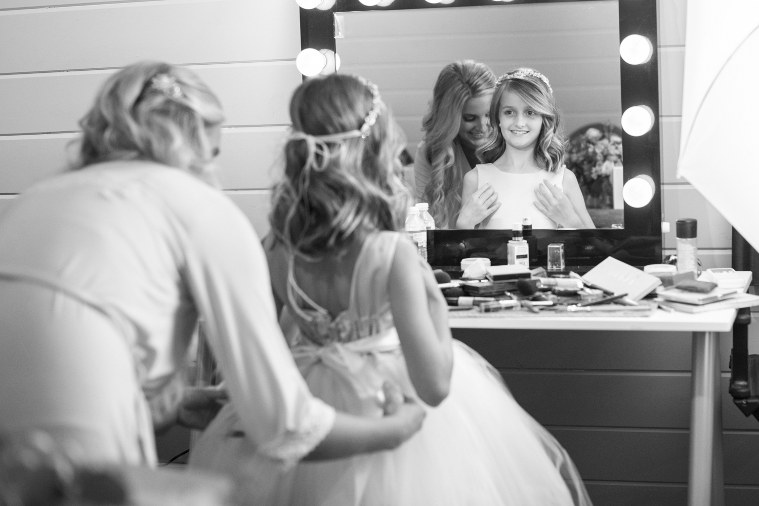 Bride helping flower girl get ready