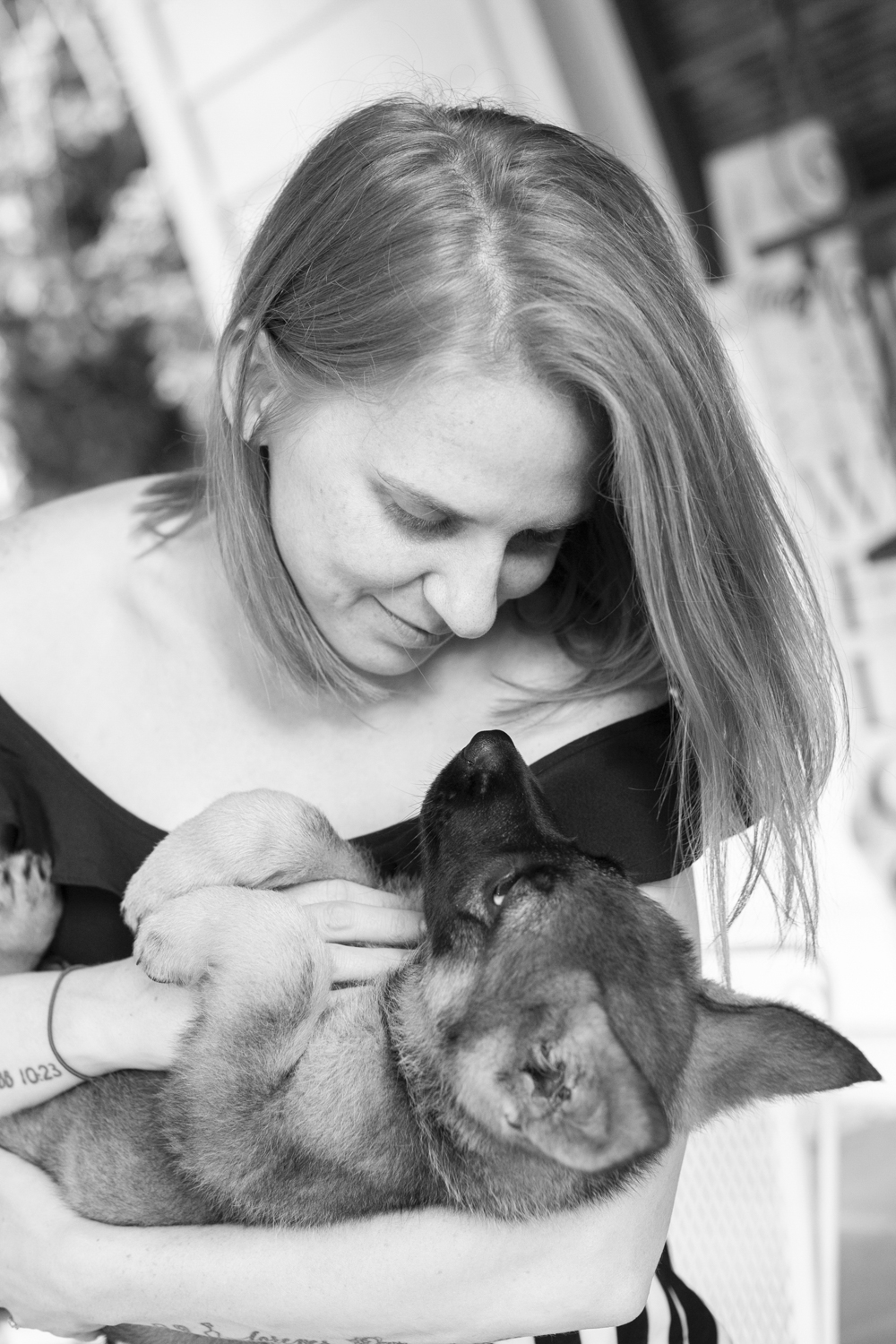 Mom snuggling German Shepherd puppy with Asheville Pet Photographer