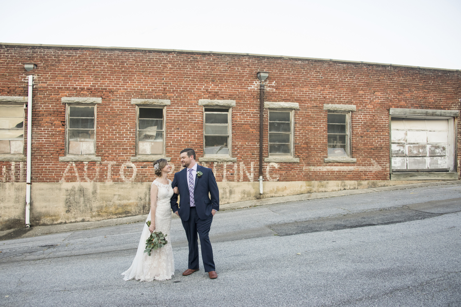 Couple's wedding portrait with vintage brick building in downtown Hendersonville, NC