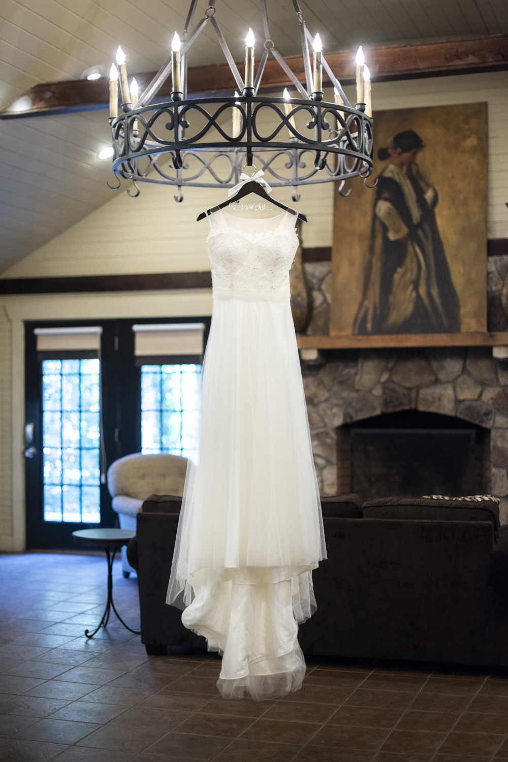 Lace wedding dress hanging fro chandelier at Hawkesdene Fall Wedding Photography