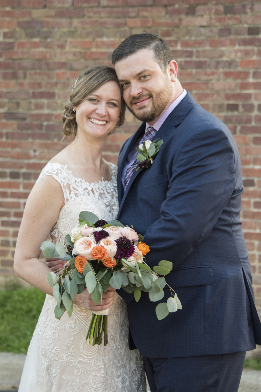 Couple's wedding portrait with vintage brick building in downtown Hendersonville, NC