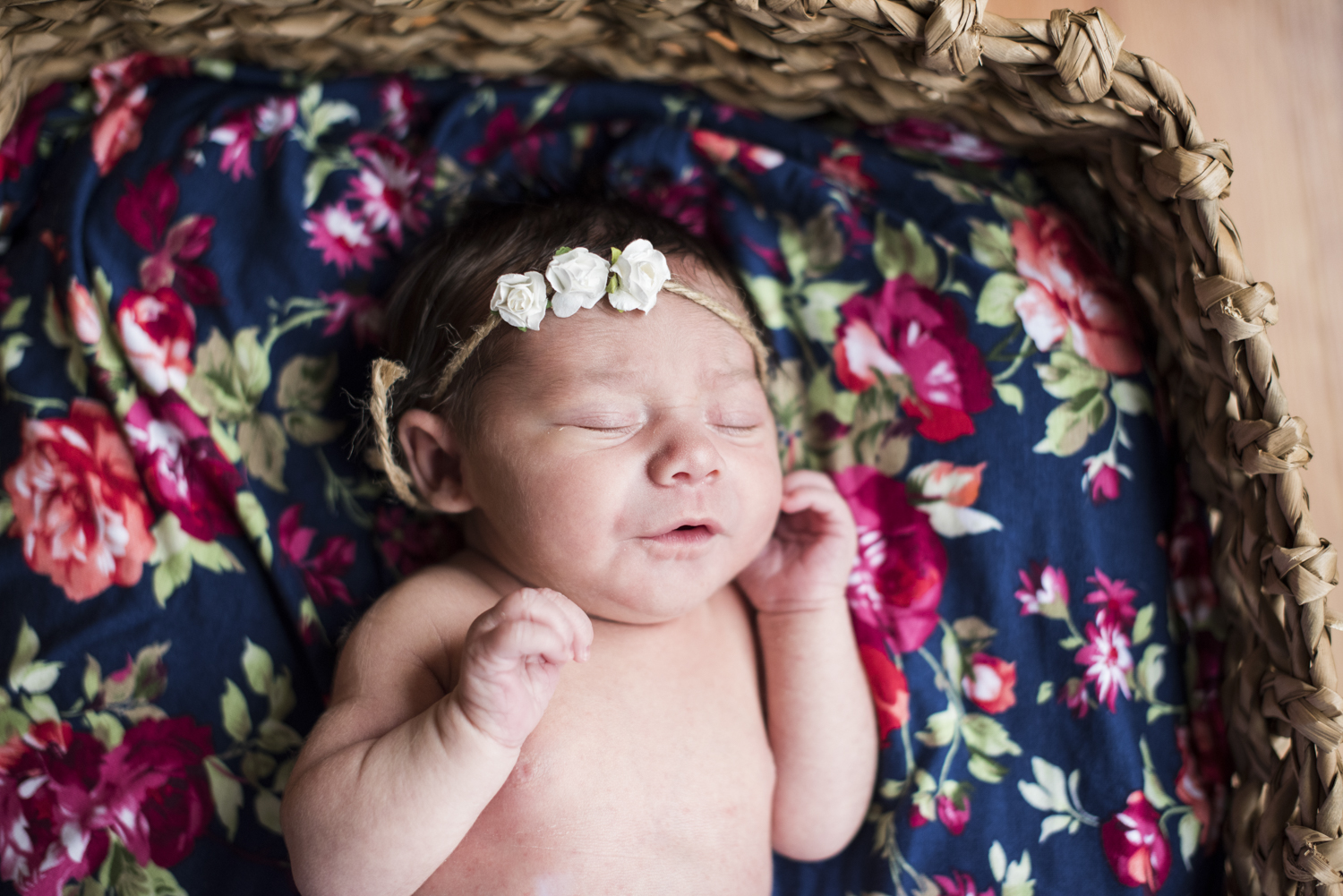 Baby girl in basket with flower blanket