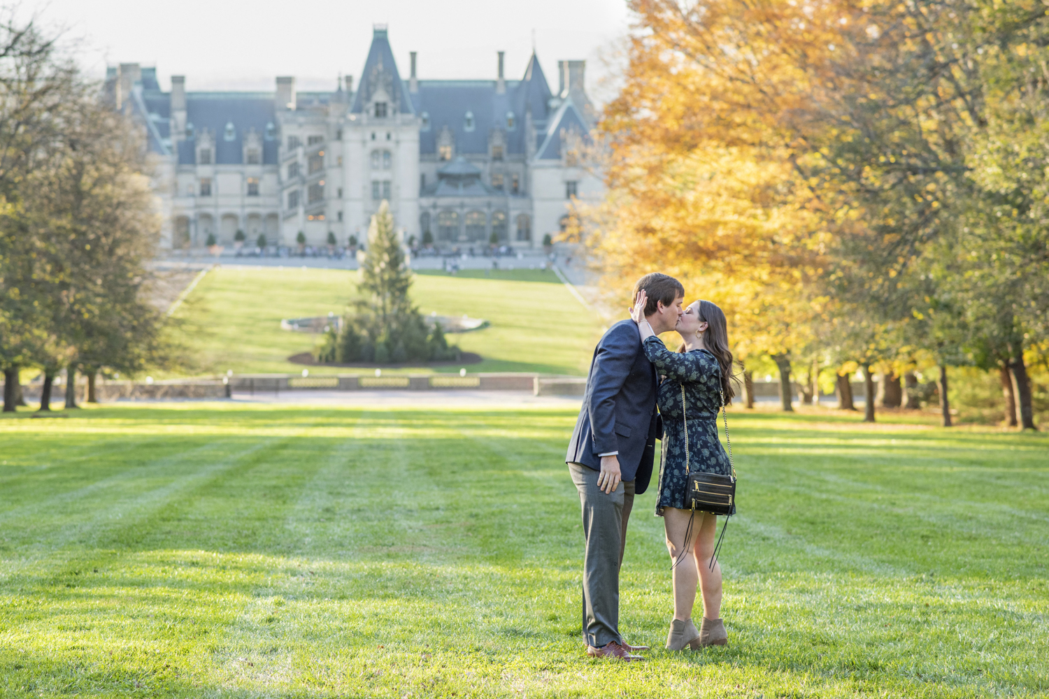 Couple kissing after proposal at Biltmore Estate fall engagement photography