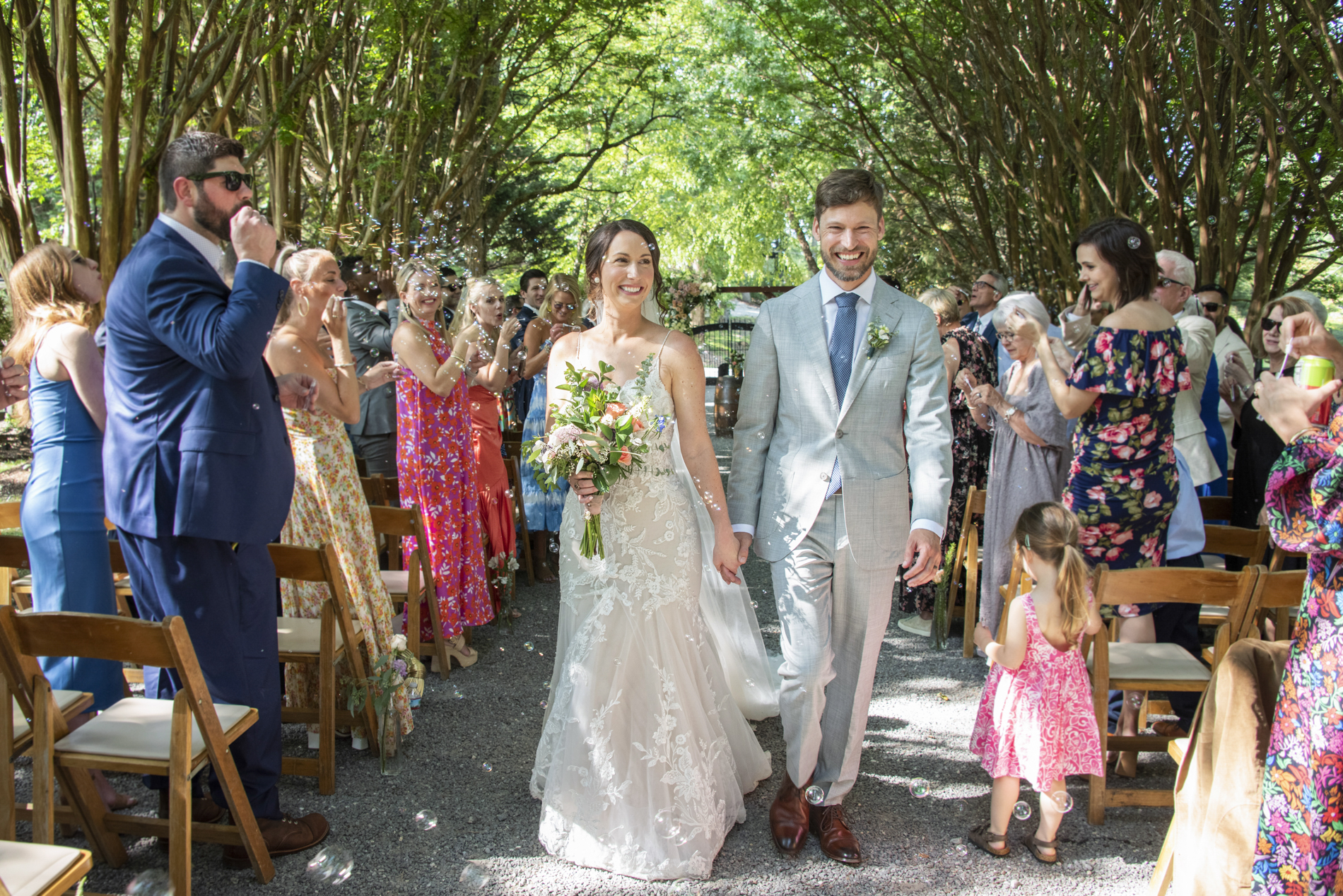 Couple walking through bubble exit with Hawkesdene Wedding Photographer