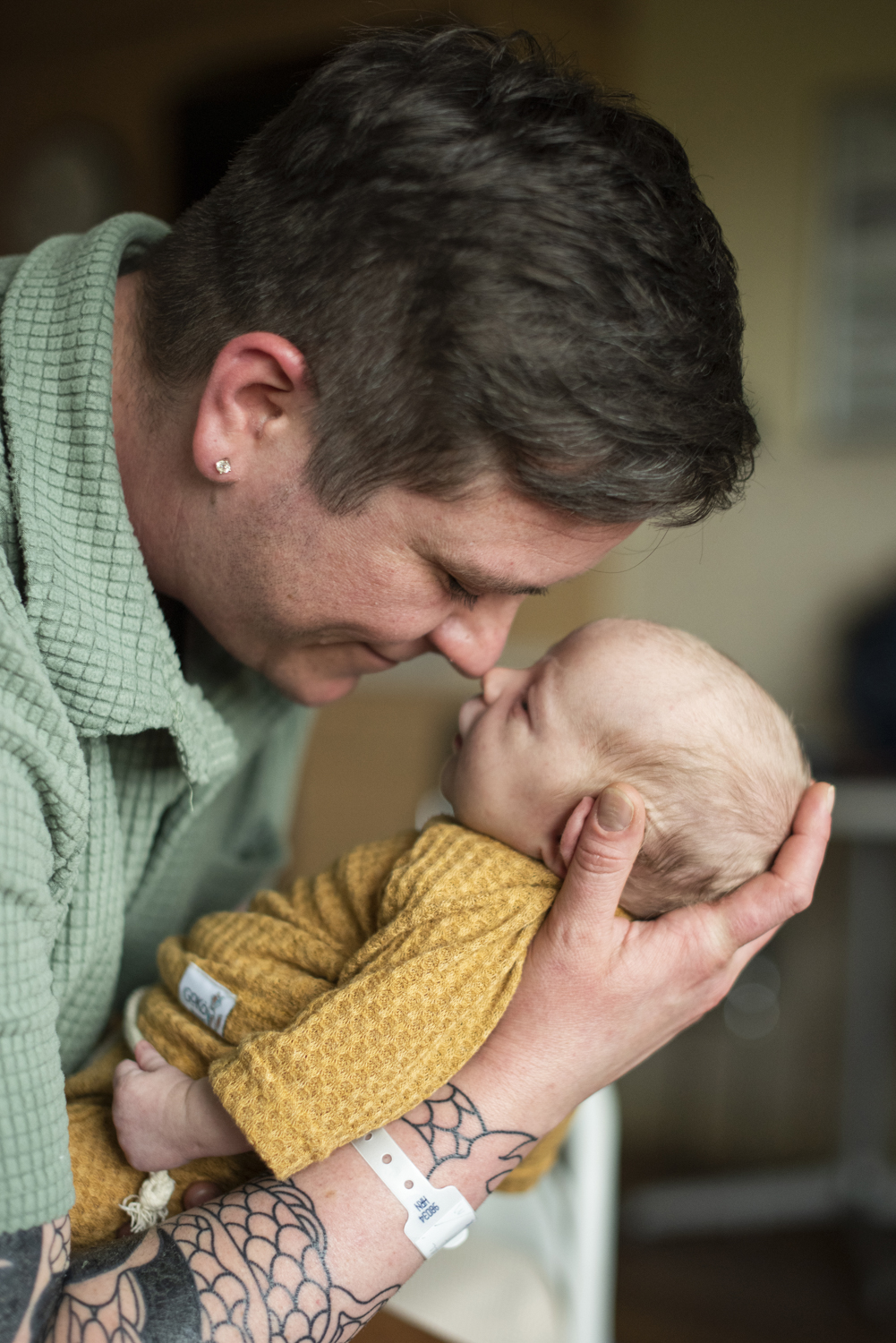 Dad and newborn baby boy touching noses