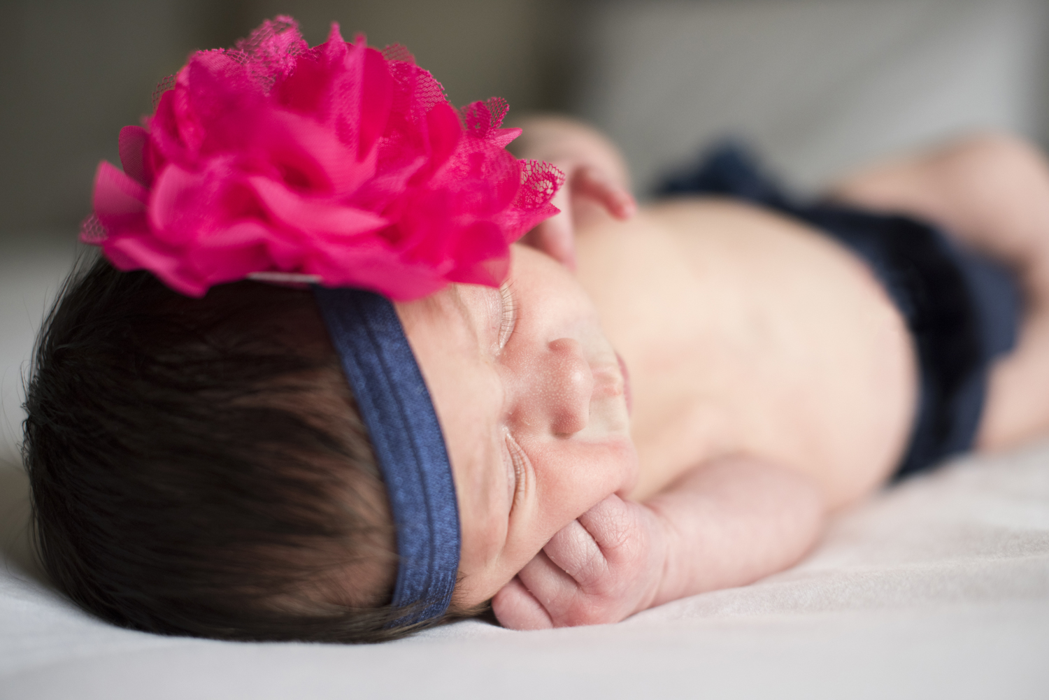 Newborn baby girl with hand under cheek