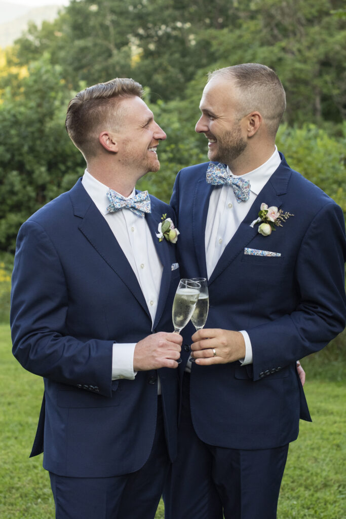 Gay wedding couple cheers champagne at Twisty Maple Wedding Photography