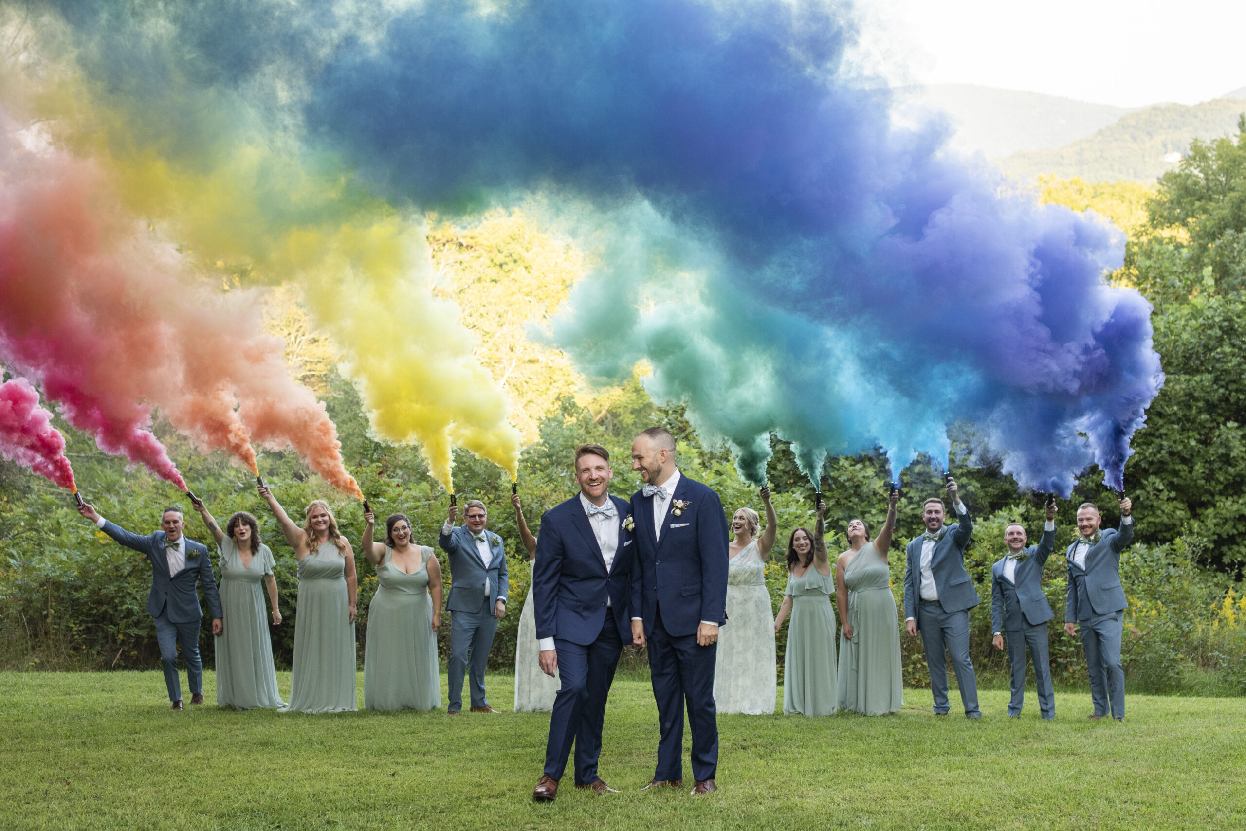 Queer couple laughing with rainbow smoke bomb at Twisty Maple Wedding Photography