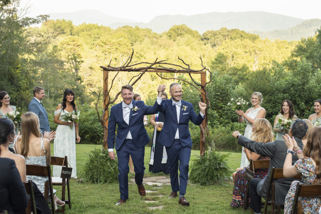 LGBTQ wedding couple cheering in the aisle at Twisty Maple Wedding Photography