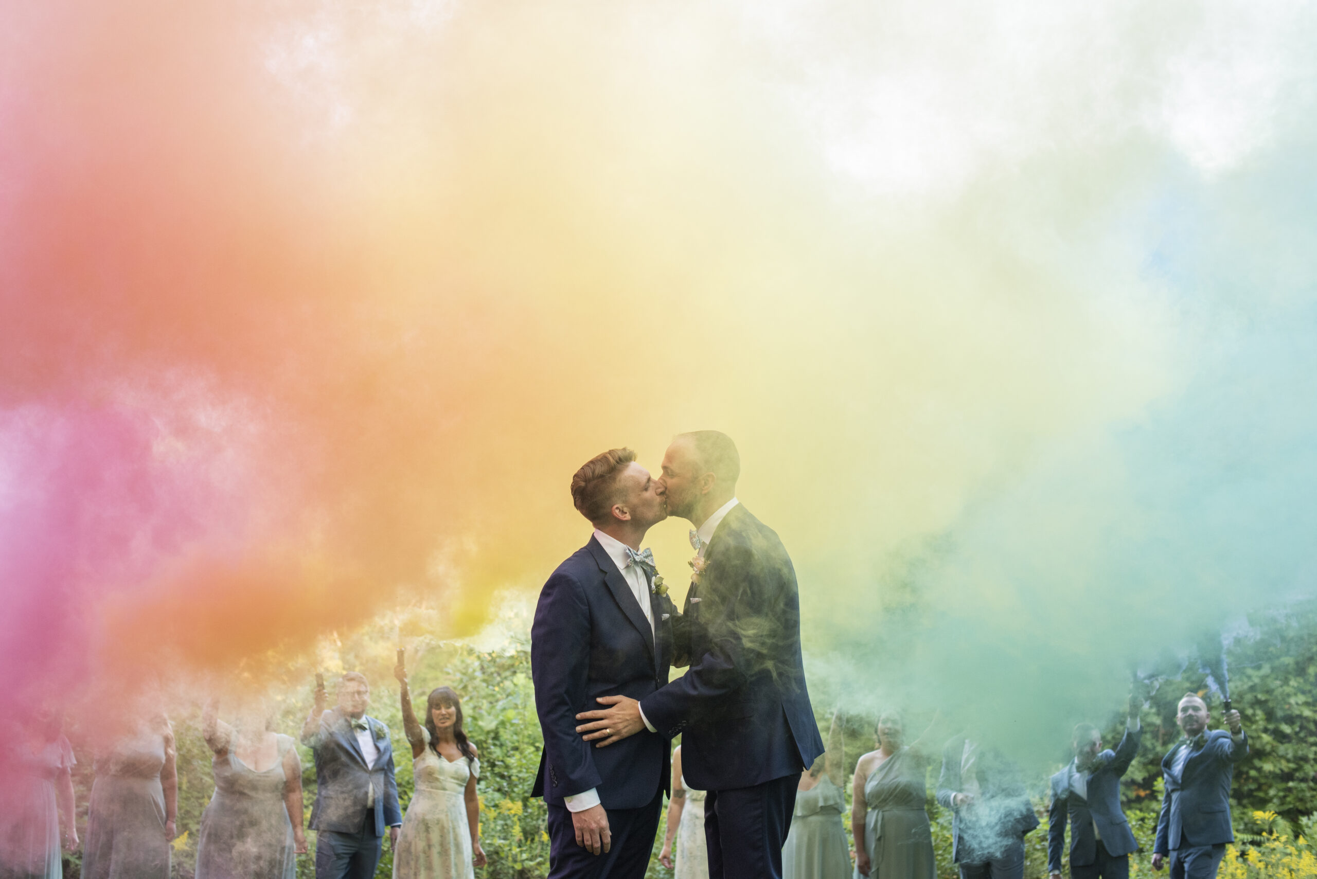 Gay couple kissing in rainbow smoke bomb at Twisty Maple Wedding Photography