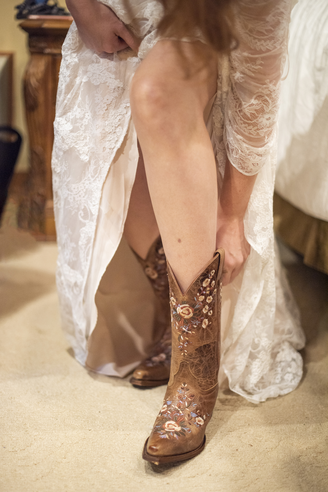 Bride putting on boots at wedding