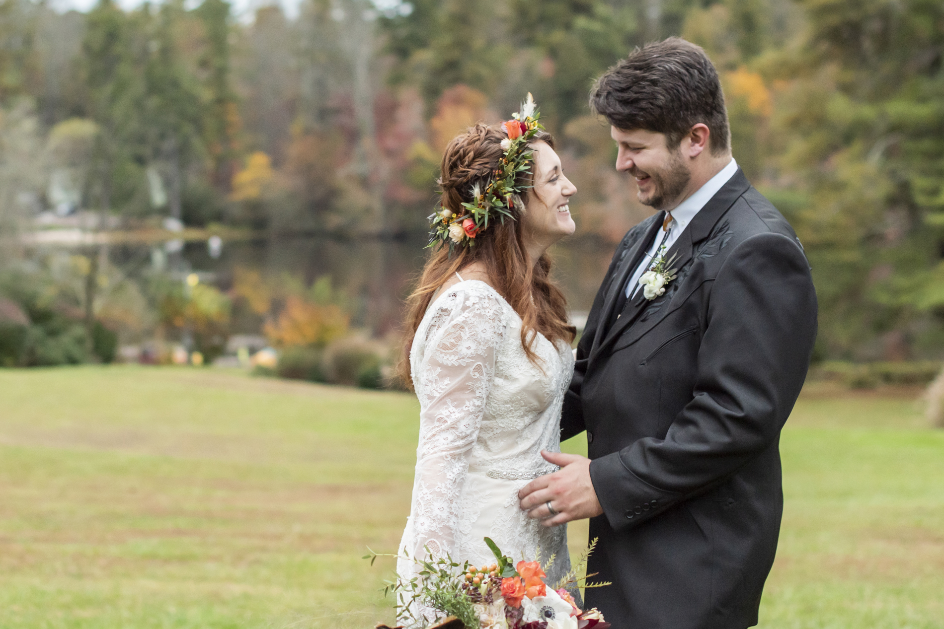 Couple laughing near lake in mountains of Hendersonville NC