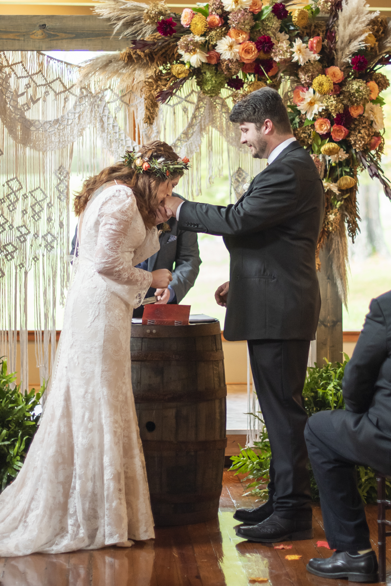 Bride kissing groom's hand during wedding ceremony