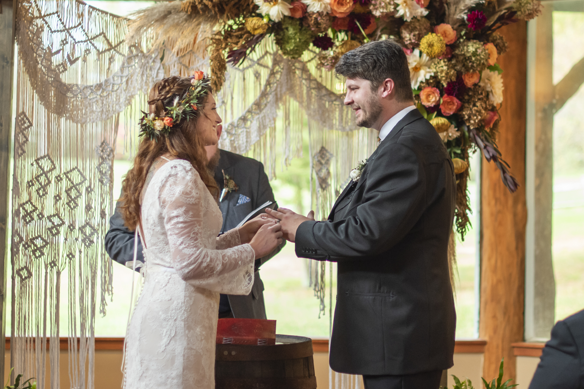 Couple during wedding ceremony at Highland Lake Inn with boho arbor