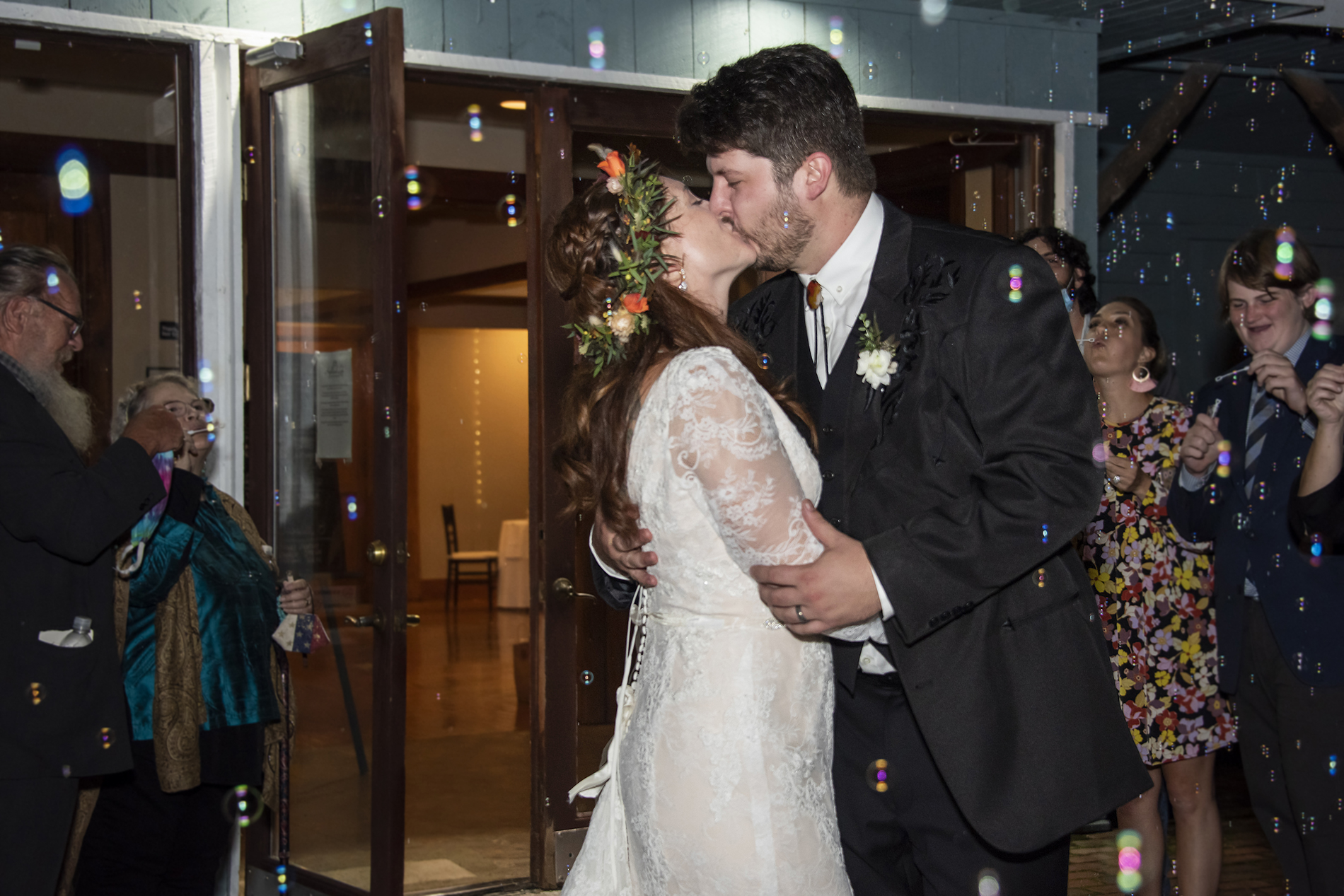 Couple kissing during wedding bubble exit