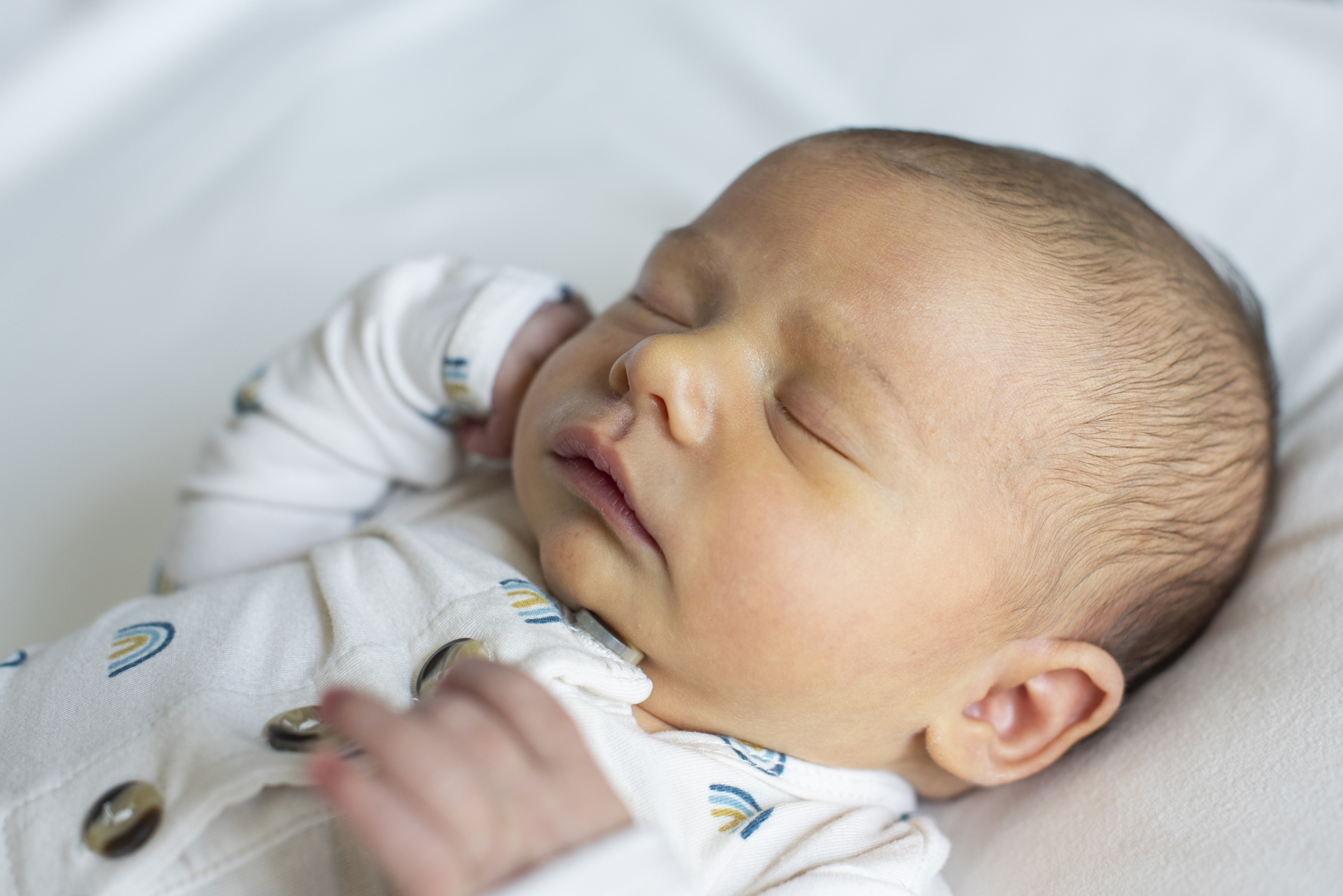 Newborn baby in rainbow pajamas