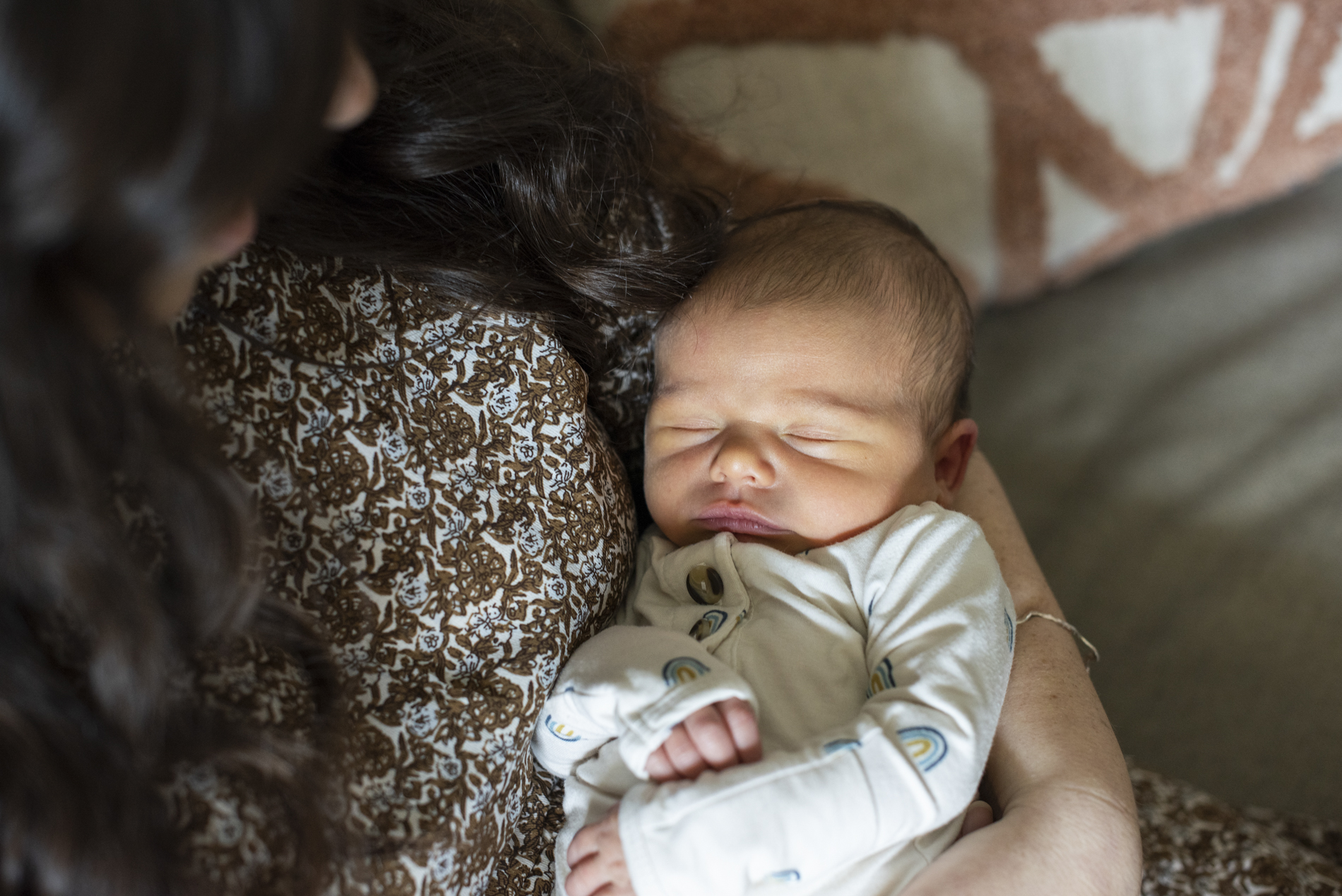 Mom looking at newborn baby at home