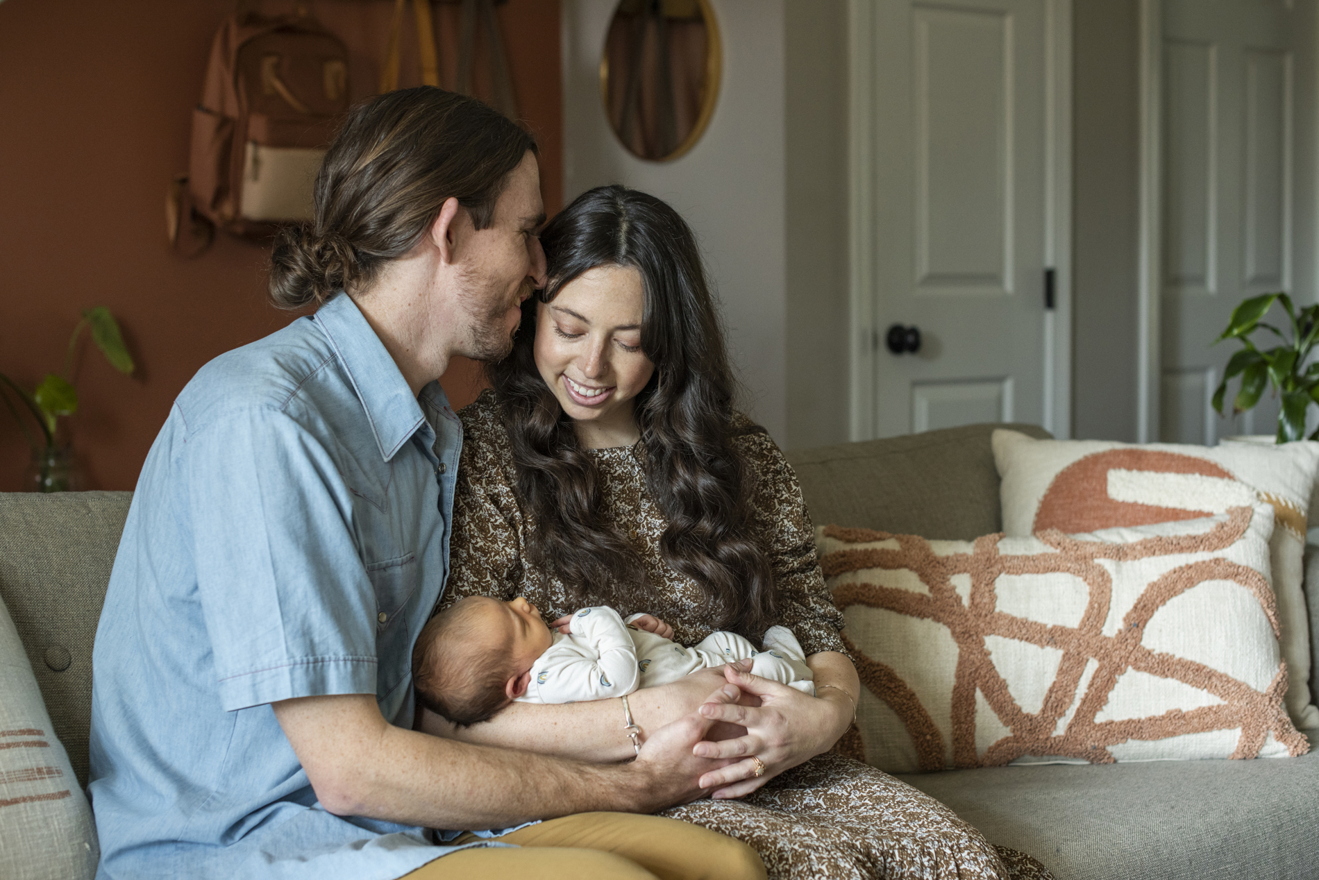 Parents snuggling newborn baby