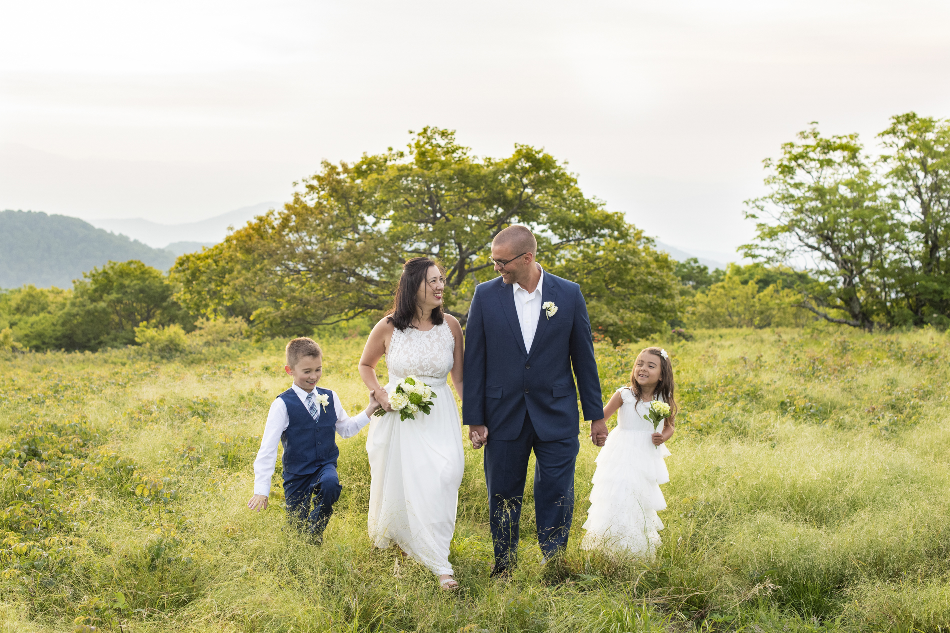 Family walking together in tall grass at Craggy Gardens summit