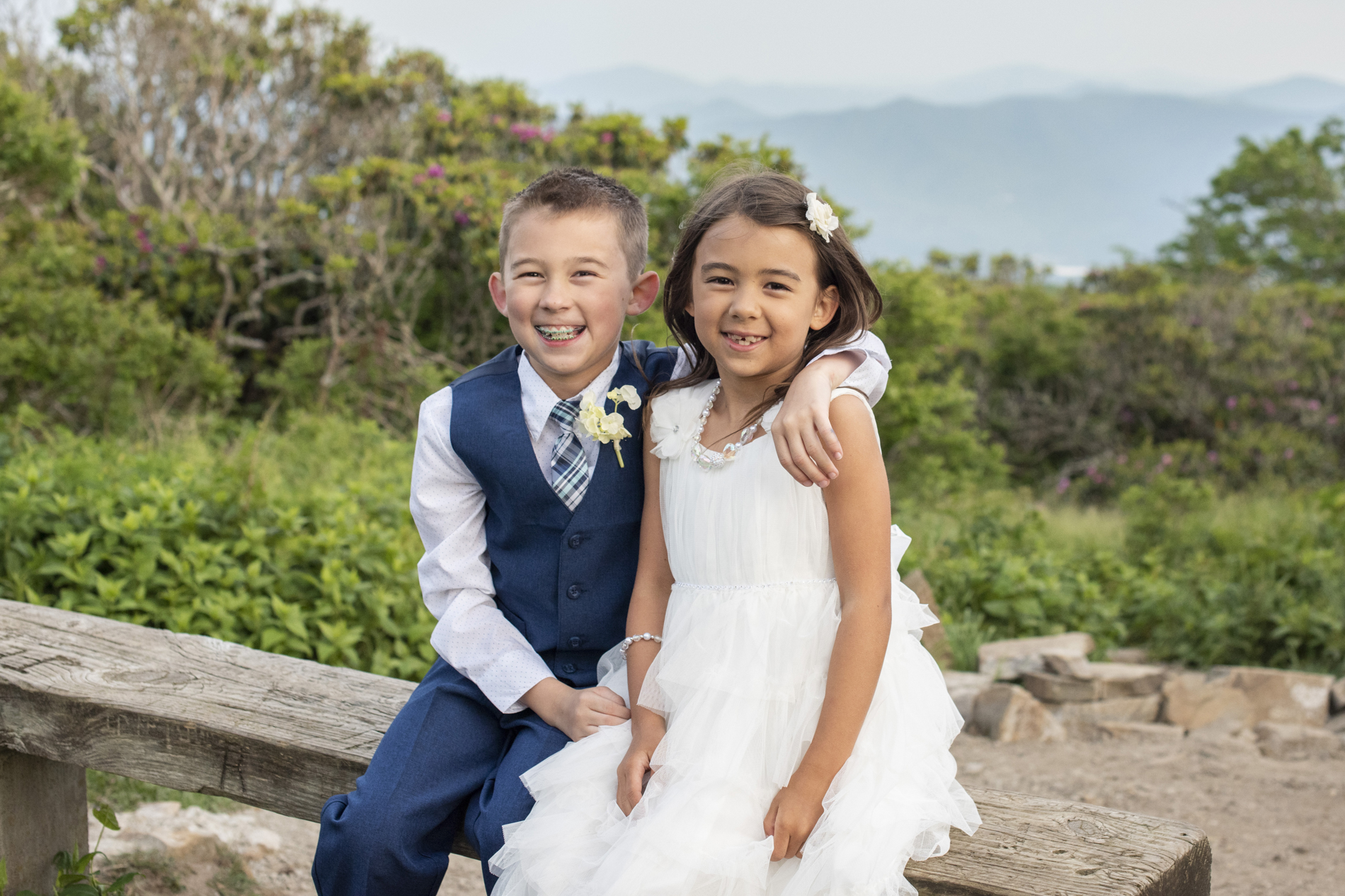 Siblings smiling with mountains behind at Craggy Gardens near Asheville, NC