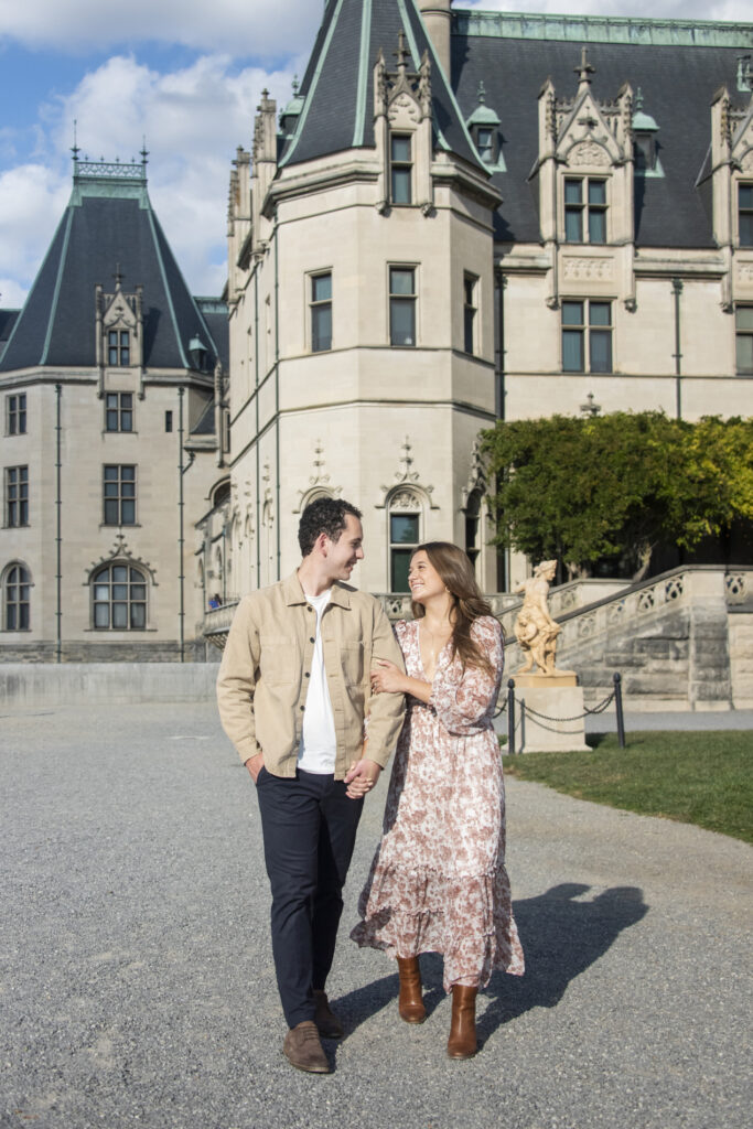 Couple walking during engagement photos at Biltmore Estate