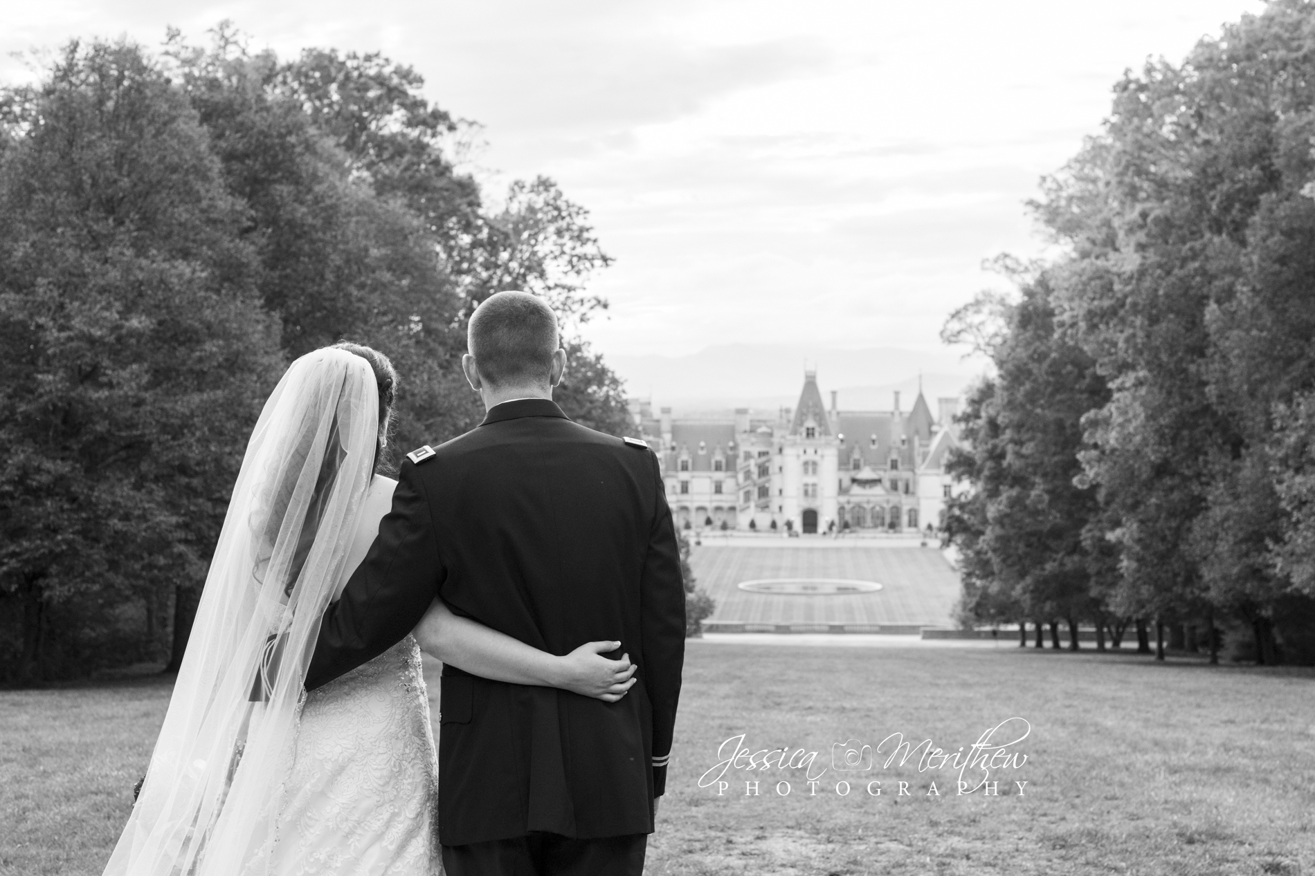 Couple looking at Biltmore house during wedding photos