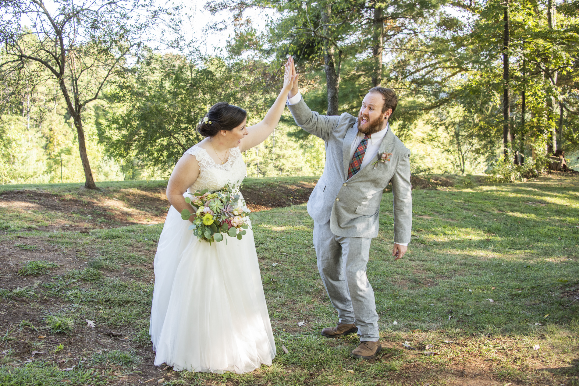 Couple sharing high five at wedding at Yesterday Spaces Asheville