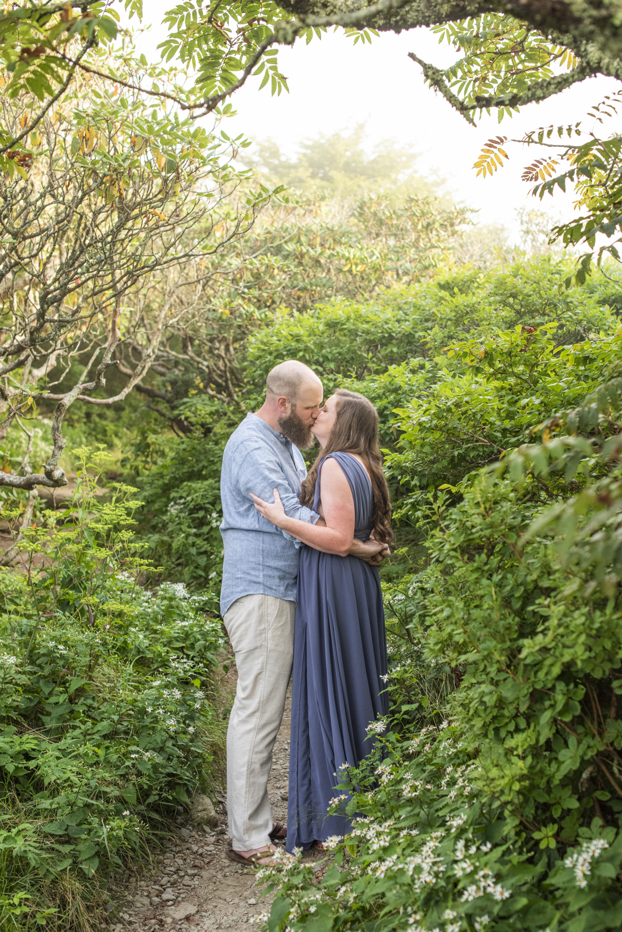 Engagement Photo of couple kissing on trail