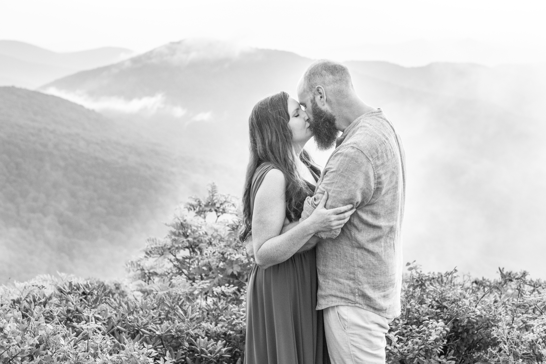 Couple kissing on mountain top during Craggy Gardens Engagement Photos