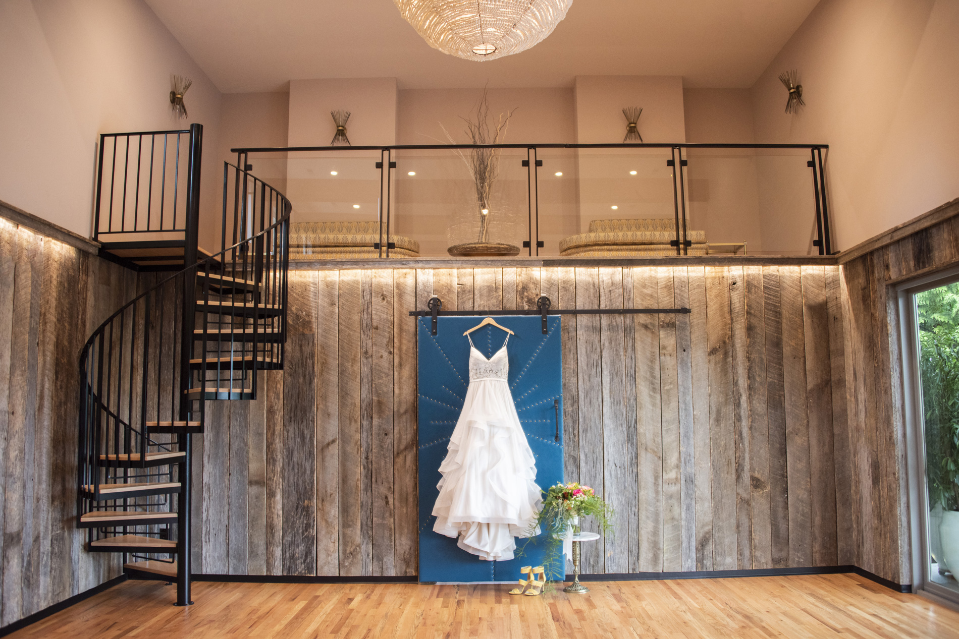 Bridal gown hanging from teal door at Haiku wedding venue in Asheville