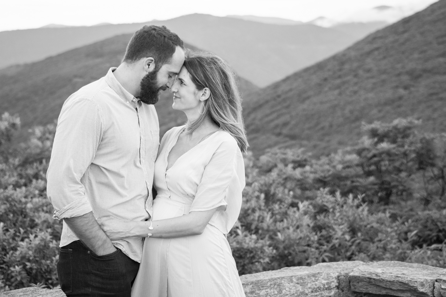 Couple snuggling on mountain top in Asheville