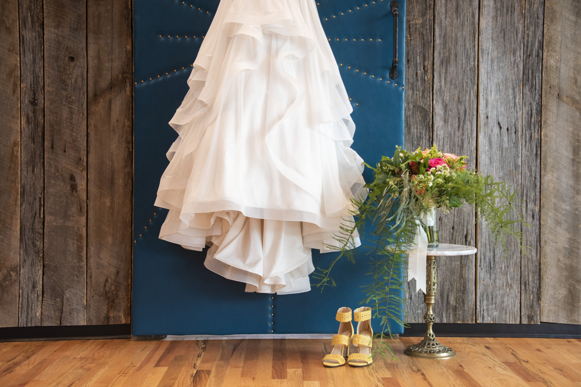 Details of hanging dress, shoes, and bouquet