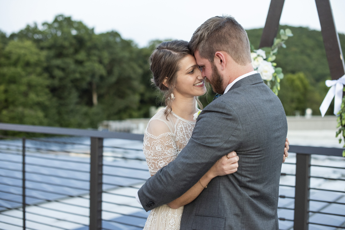 Couple snugging on rooftop at Highland Brewing Wedding