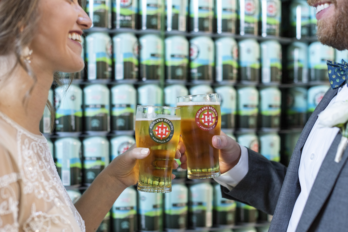 Couple cheers beer in can room at Highland Brewing Wedding