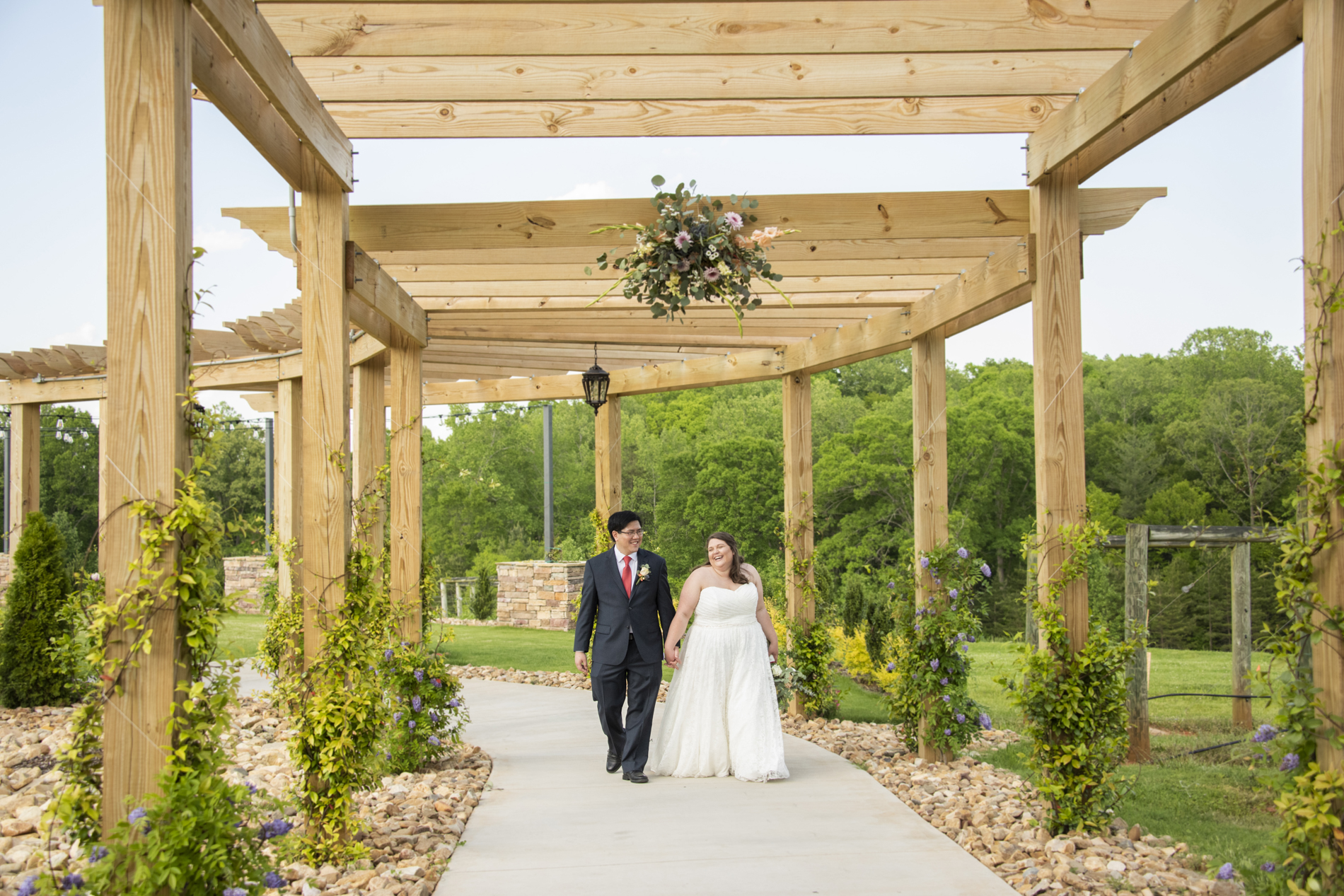 Couple walking under arbor walkway at Spinning Leaf Wedding