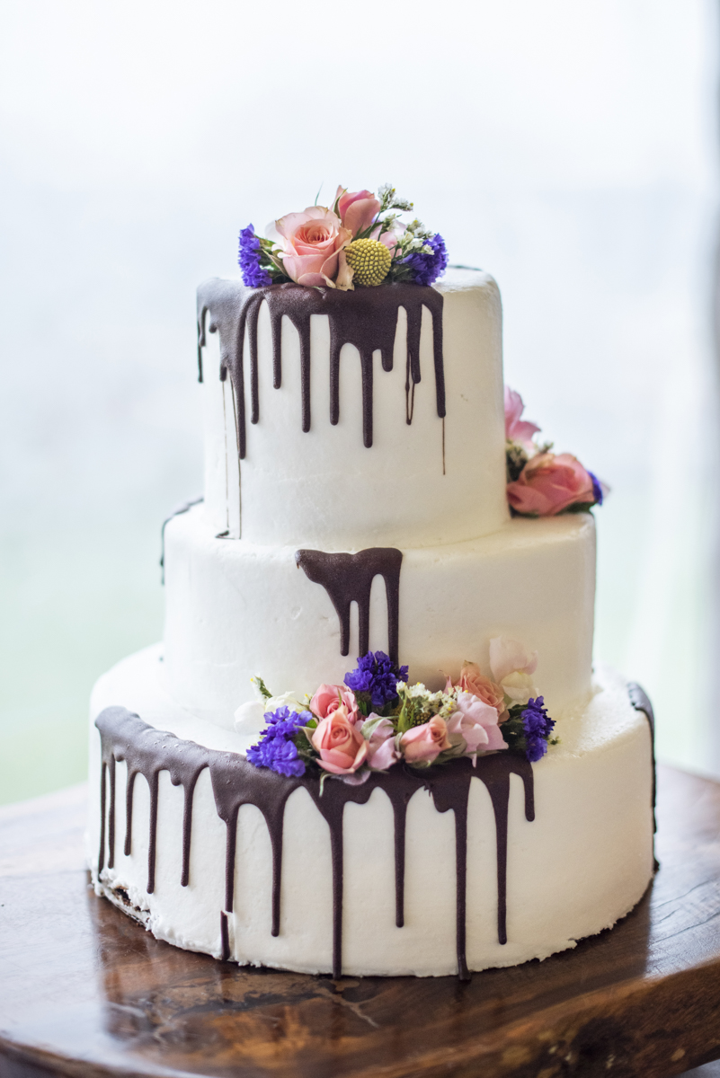 Wedding cake with chocolate drip and flowers at Connestee Falls Wedding