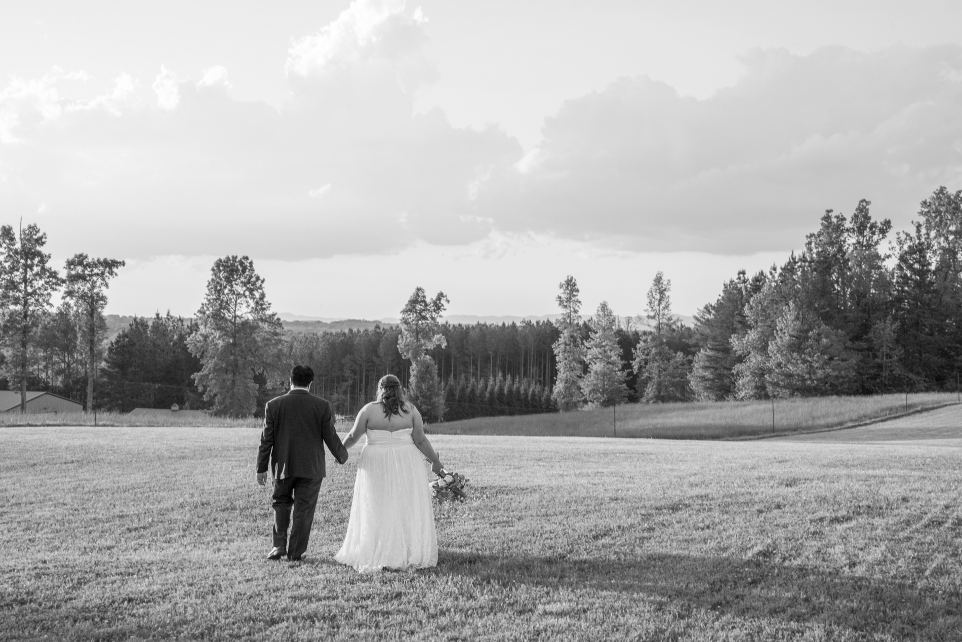 Couple walking across field at Spinning Leaf Wedding