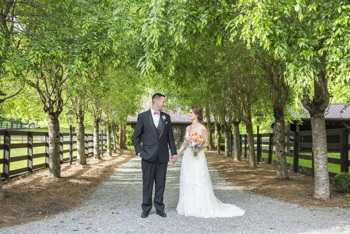 Couple holding hands in alley near barn