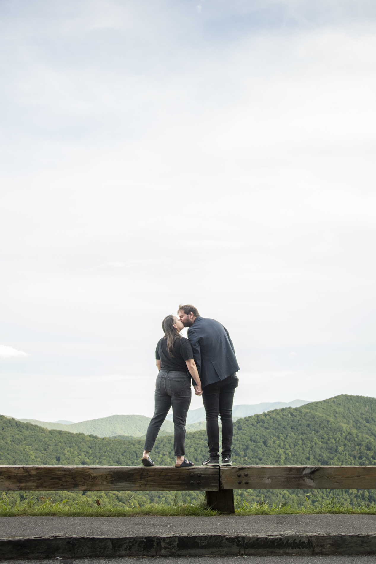 Couple kissing while standing on railing
