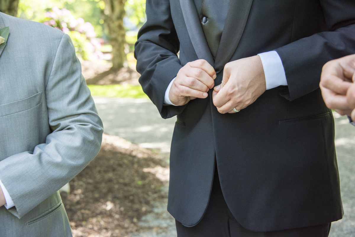 Groom buttoning jacket at wedding